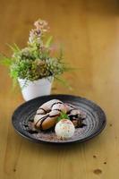 delicioso pequeno bolo e chocolate no prato com fundo de flores na mesa foto