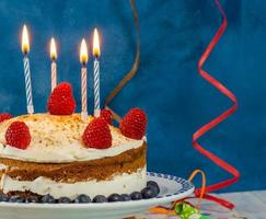 bolo de aniversario com velas e serpentina foto