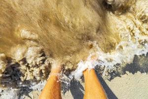 pés na água e areia da praia playa del carmen méxico. foto