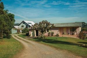 bento goncalves, brasil - 12 de julho de 2019. charmosa casa de campo moderna com caminho e um jardim exuberante em uma paisagem rural perto de bento goncalves. foto