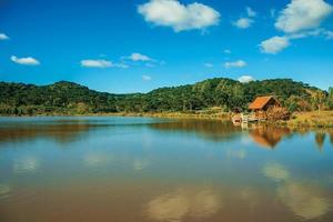 cambara do sul, brasil - 18 de julho de 2019. pequena cabana rústica refletida no lago de águas cristalinas e morros cobertos por arvoredo próximo a cambara do sul. foto