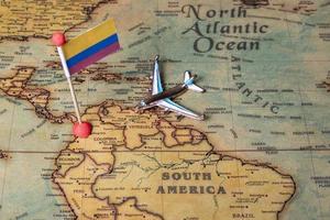bandeira da Colômbia e o avião no mapa mundial. foto