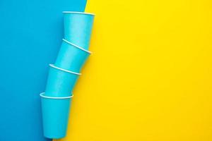 copos descartáveis de papel azul fundo amarelo e azul foto