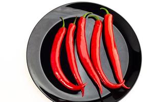 pimenta malagueta vermelha no prato isolado em um fundo branco foto