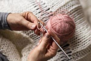 vista elevada tricotando com linha rosa foto