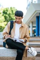 um homem sentado e lendo um livro nas escadas. foto