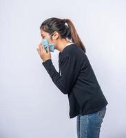 uma mulher tossindo e cobrindo a boca com a mão foto