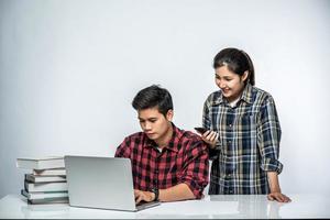 mulheres ensinam homens a trabalhar com laptops no trabalho. foto