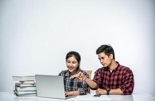 homens ensinam mulheres a trabalhar com laptops no trabalho. foto