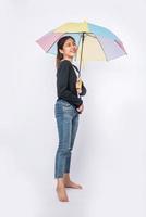 uma mulher vestindo uma camisa preta e de pé com um guarda-chuva foto