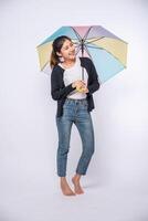 uma mulher vestindo uma camisa preta e de pé com um guarda-chuva foto