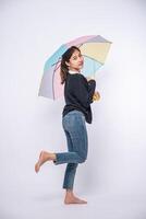 uma mulher vestindo uma camisa preta e de pé com um guarda-chuva foto