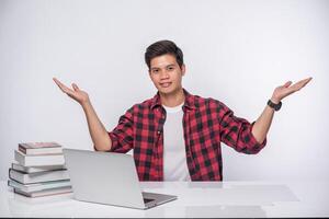 um homem vestindo uma camisa listrada usa um laptop para trabalhar. foto