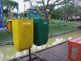 lixeiras amarelas para resíduos não orgânicos que não podem ser reciclados e verdes para resíduos orgânicos recicláveis. colocado em um parque foto