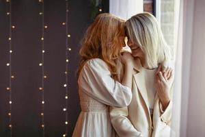 casal de lésbicas jantando em um restaurante. uma garota abraça seu amado sussurrando em seu ouvido