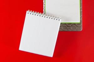 layout minimalista para design. material de escritório - cadernos em um fundo vermelho. foto