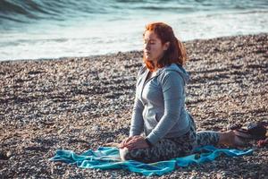 menina meditando na praia foto