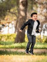 menino posando no parque. expressões diferentes. pulando foto