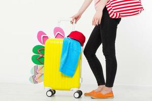 menina com mala isolada no fundo branco. férias de verão. chinelos ou chinelos de verão. mala de viagem ou bolsa. brincar. copie o espaço. modelo. em branco. foto