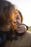 uma criança dá uma flor para sua mãe foto