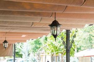 telhado com lâmpada decorativa no café de verão ao ar livre. toldo de lona no restaurante na rua foto