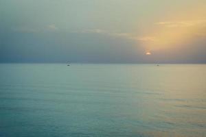 pôr do sol sobre o mar. silhueta de barcos no horizonte foto