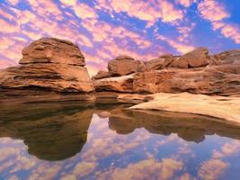 natureza paisagem vista de dunas de areia e campo rochoso com reflexo de água em sam phan bok um canyon junto ao rio mekong no grand canyon da tailândia. foto