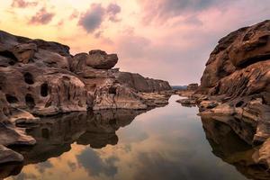 natureza paisagem vista de dunas de areia e campo rochoso com reflexo de água em sam phan bok um canyon junto ao rio mekong no grand canyon da tailândia. foto