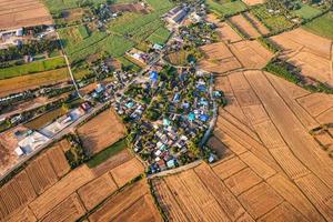 vila suburbana entre campos de arroz colhidos e via no campo foto