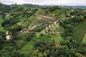 vista aérea do resort cabana na encosta entre a montanha na floresta tropical em dia chuvoso foto