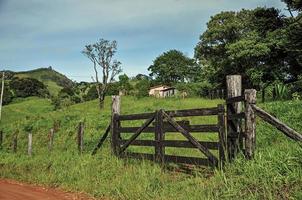 vista do portal da fazenda ao lado de uma estrada rural foto