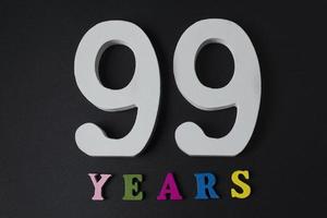 letras e números noventa e nove anos em um fundo preto. foto