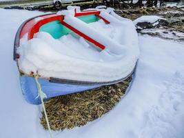 barco coberto de neve colorido na costa do fiorde, na Noruega. foto