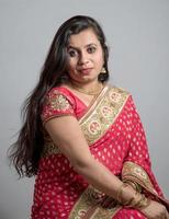 linda jovem posando em saree tradicional indiano em fundo branco. foto