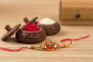 fundo indiano festival raksha bandhan com um elegante rakhi, grãos de arroz e kumkum. uma pulseira tradicional indiana que é um símbolo de amor entre irmãos e irmãs. foto