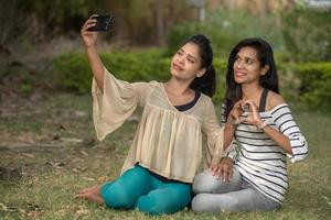 duas lindas amigas tomando selfie com smartphone ao ar livre. foto