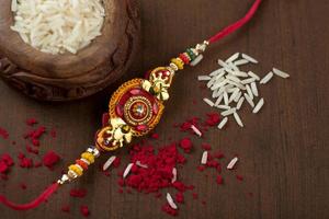 fundo indiano festival raksha bandhan com um elegante rakhi, grãos de arroz e kumkum. uma pulseira tradicional indiana que é um símbolo de amor entre irmãos e irmãs. foto