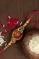 fundo indiano festival raksha bandhan com um elegante rakhi, grãos de arroz e kumkum. uma pulseira tradicional indiana que é um símbolo de amor entre irmãos e irmãs.