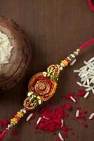 fundo indiano festival raksha bandhan com um elegante rakhi, grãos de arroz e kumkum. uma pulseira tradicional indiana que é um símbolo de amor entre irmãos e irmãs.