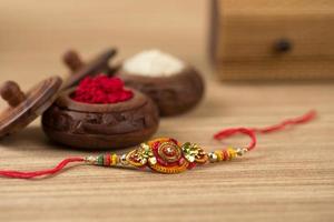 fundo indiano festival raksha bandhan com um elegante rakhi, grãos de arroz e kumkum. uma pulseira tradicional indiana que é um símbolo de amor entre irmãos e irmãs. foto