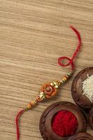 fundo indiano festival raksha bandhan com um elegante rakhi, grãos de arroz e kumkum. uma pulseira tradicional indiana que é um símbolo de amor entre irmãos e irmãs. foto