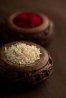 recipiente de kumkum e grãos de arroz. pós de cores naturais são usados durante a adoração a Deus e em ocasiões auspiciosas.