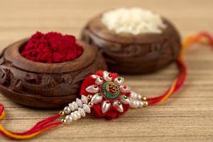 fundo indiano festival raksha bandhan com um elegante rakhi, grãos de arroz e kumkum. uma pulseira tradicional indiana que é um símbolo de amor entre irmãos e irmãs. foto