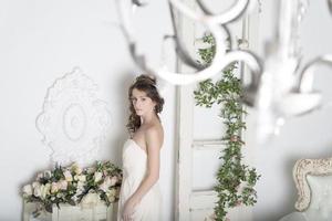 garota em um vestido branco com flores na casa. foto