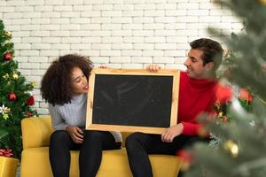 casais na sala de estar durante o feliz natal e feliz ano novo foto