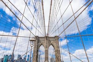 ponte de brooklyn com manhattan no centro da cidade e paisagem urbana em dia ensolarado com céu azul claro de nova york eua foto