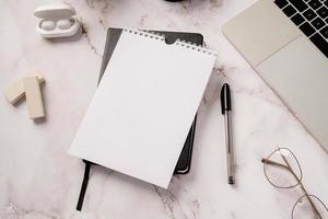 vista de cima, agenda em branco, notebook e laptop em fundo de mármore cinza claro foto
