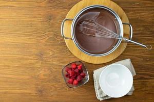 pudim de chocolate com framboesas em uma mesa de madeira. foto