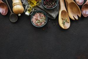 utensílios de cozinha de madeira antigos e temperos como fronteira foto