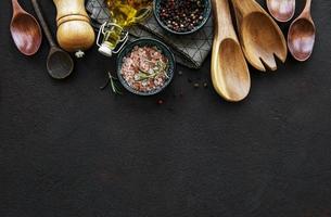 utensílios de cozinha de madeira antigos e temperos como fronteira foto